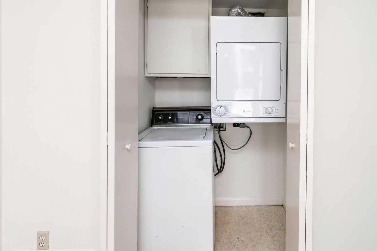 Hickory Hill Townhomes laundry. View of washer and dryer. both full size, washer sets on floor while the dryer hangs from the wall, leaving room for a hamper under dryer