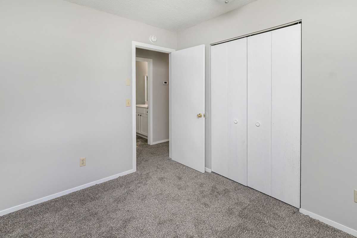 Township bedroom 1, view from farthest corner of room looking a double bifold doors to closet, door to hallway and partial view of the bathroom