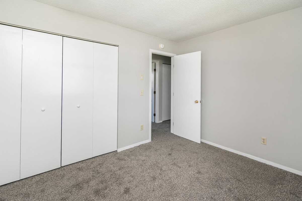Township 2nd bedroom, view from farthest corner in bedroom showing the double bifold doors to closet and door into hall way .