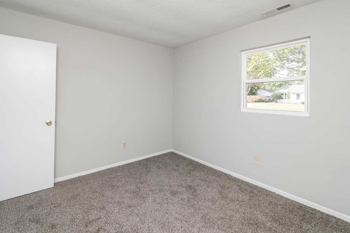 Township 2nd bedroom with one window, dark gray carpet and light gray walls with white trim