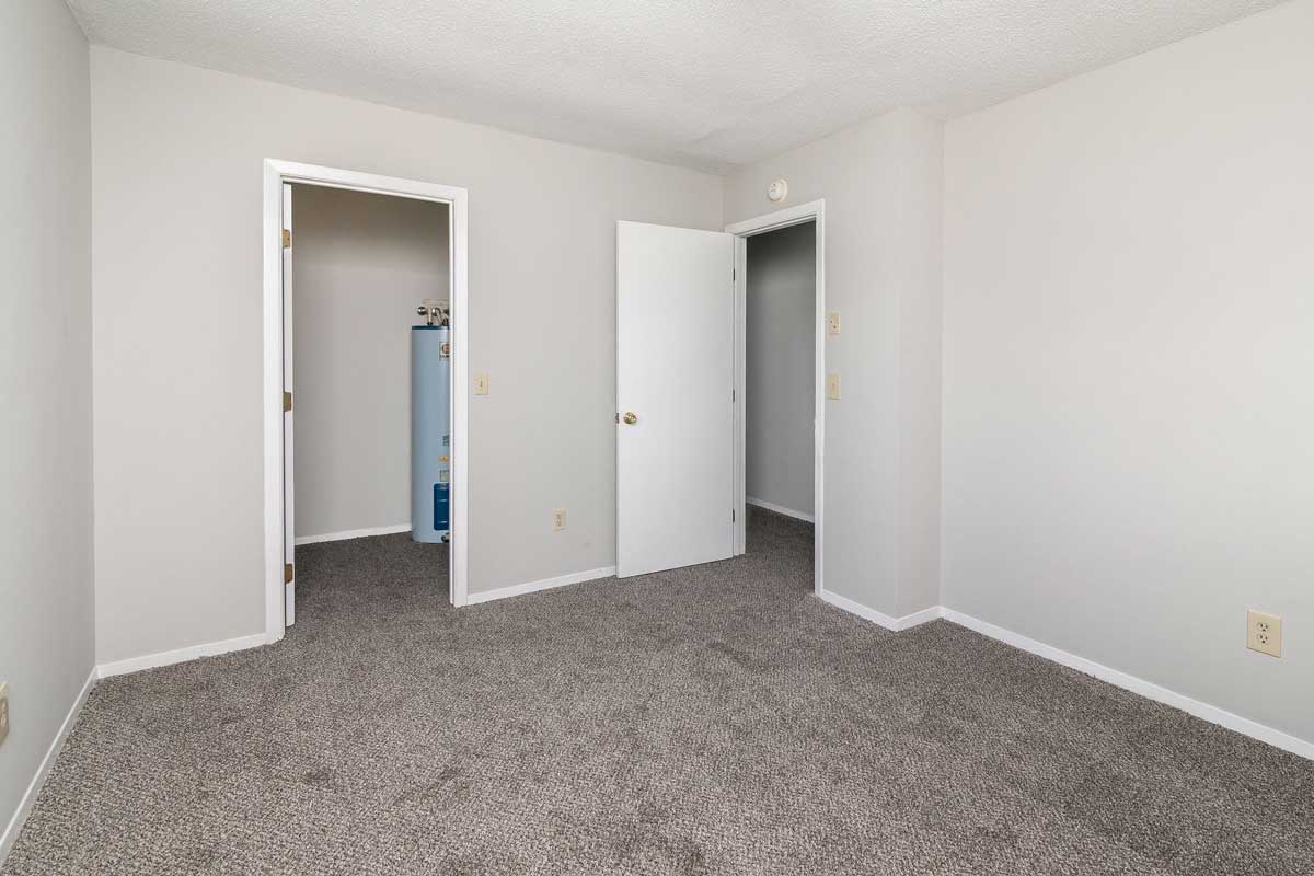 Township master bedroom view of door and door to walk in closet Light gray painted walls, dark gray carpet